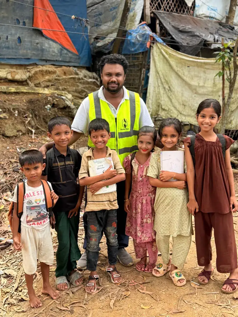 Social Care team member with Rohingya schoolchildren and their new books